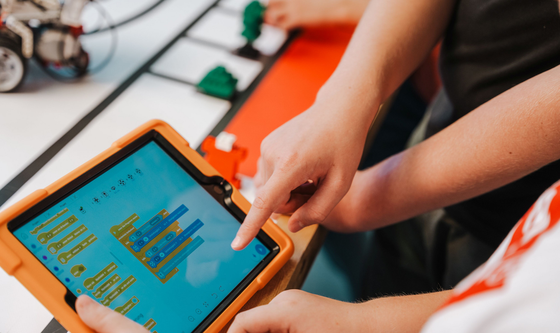 Kinder zeigen in der Schule auf ein Tablet. Bild: BM RLP/Weissmantel