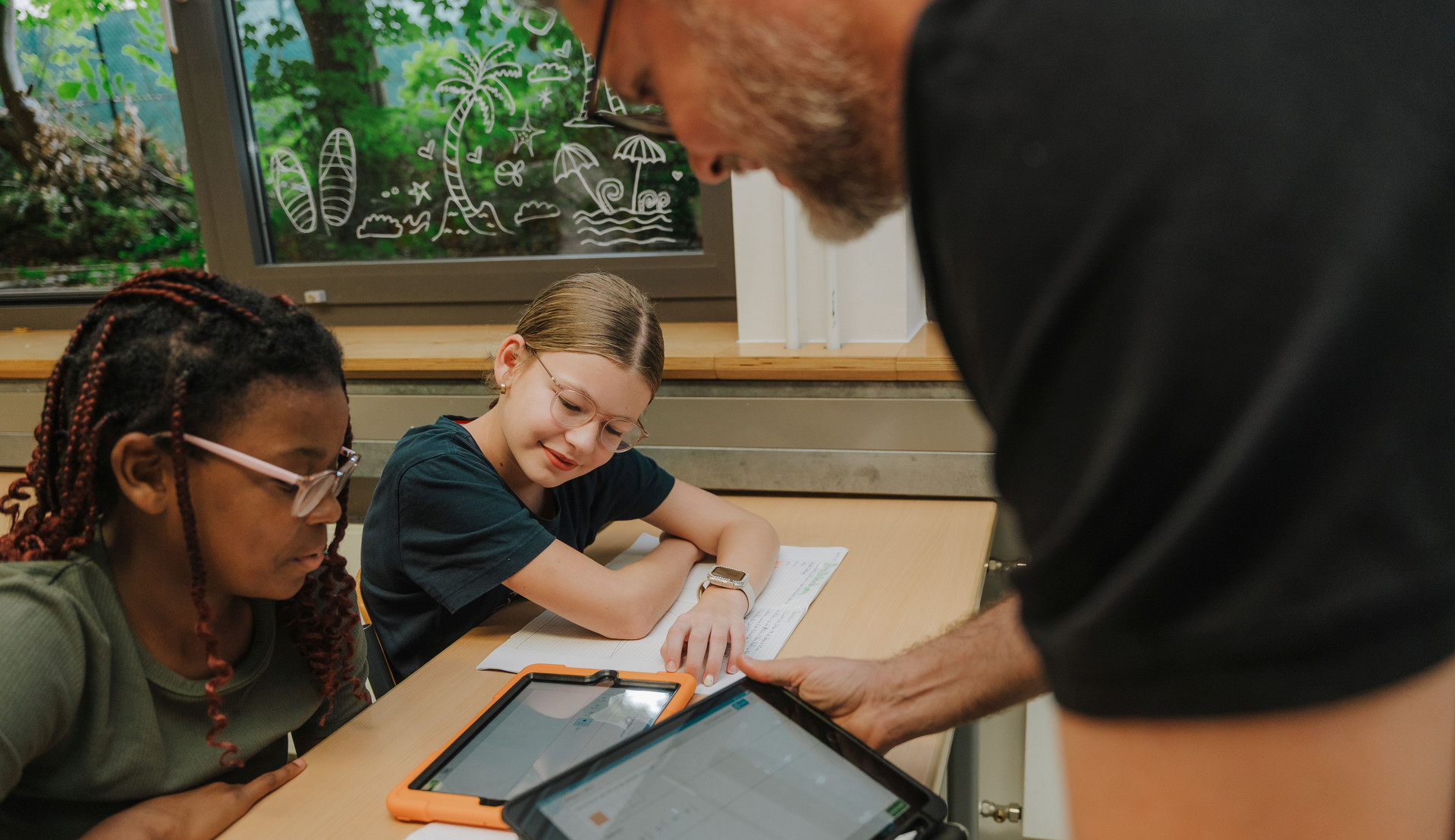 Ein Lehrer erklärt Kindern etwas auf einem Tablet. Bild: BM RLP/Weissmantel
